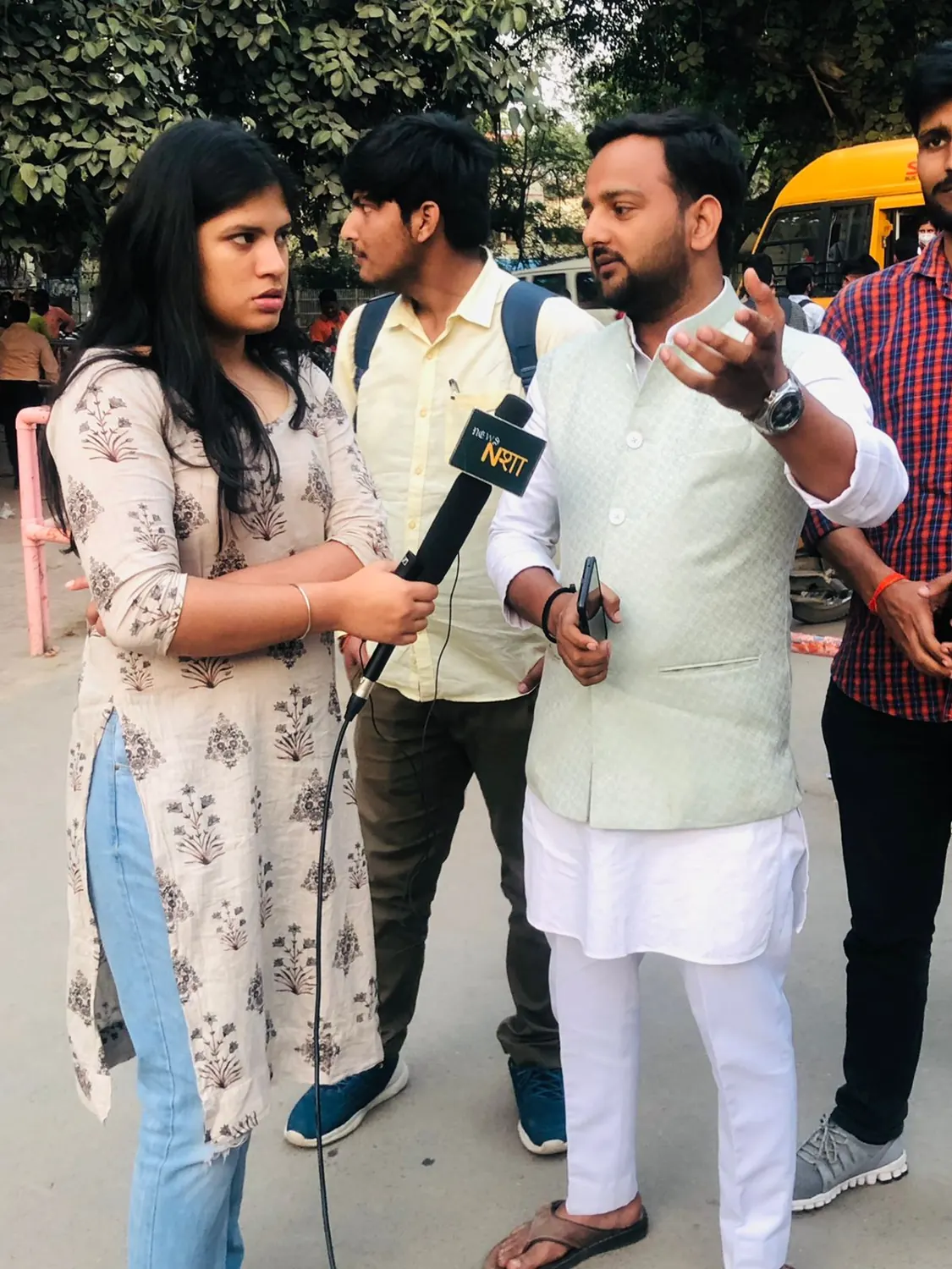 Rahul Awasthi giving a street interview to a news reporter with a microphone