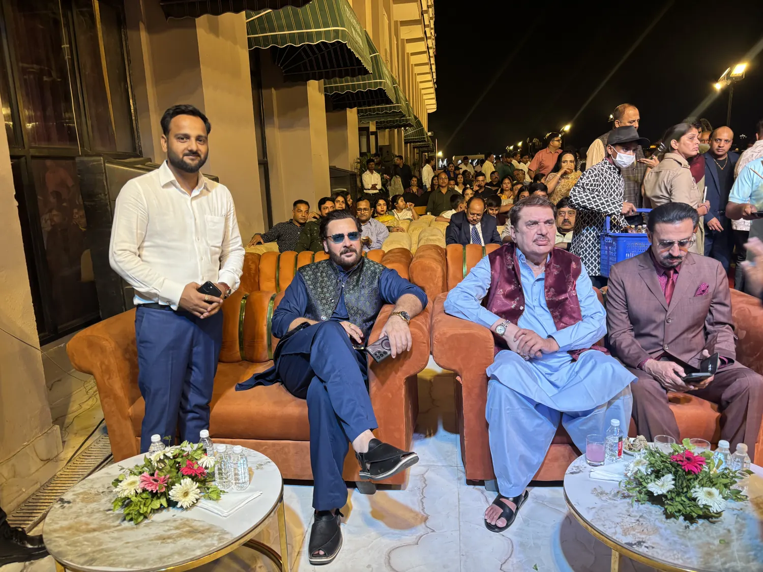 Rahul Awasthi standing near seated guests at an evening event